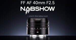 A lens labeled "7Artisans" is centered below text reading "FF AF 40mm F2.5 NABSHOW." The lens features a sleek design with focus and aperture rings, numbers marking distances in meters, and a switch labeled "A/M.