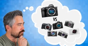 A man with a beard and gray hair thinking, with a thought bubble showing camera comparisons. Inside the bubble, there's a larger DSLR on top and four smaller cameras below labeled "VS," on a blue textured background.
