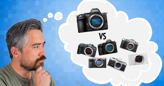 A man with a beard and gray hair thinking, with a thought bubble showing camera comparisons. Inside the bubble, there's a larger DSLR on top and four smaller cameras below labeled "VS," on a blue textured background.