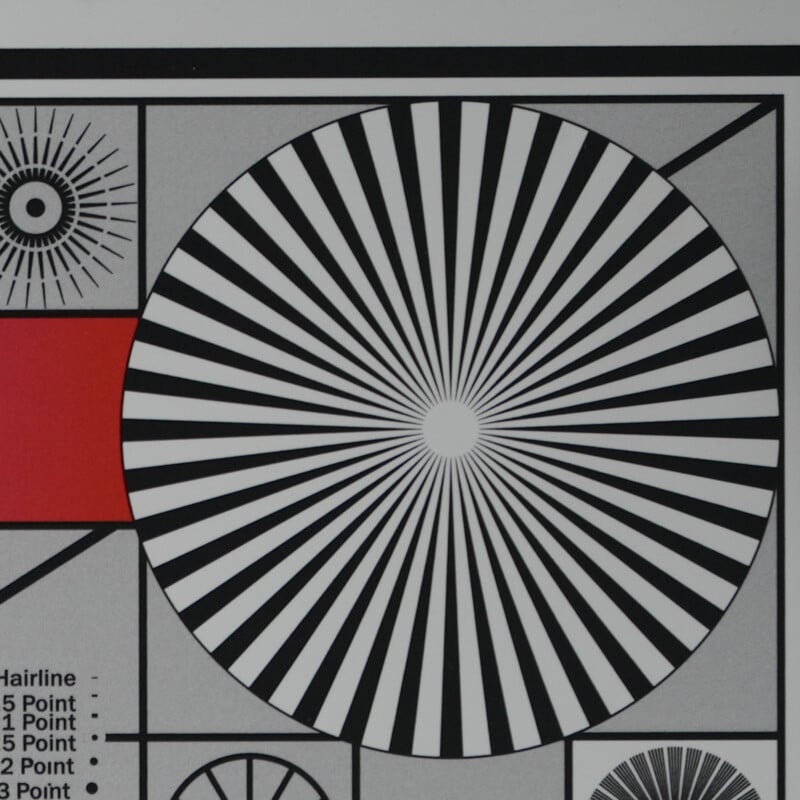 A black and white radial test pattern with concentric lines forms a large circle in the center. A red rectangle is on the left, with smaller geometric patterns and text in the corners.
