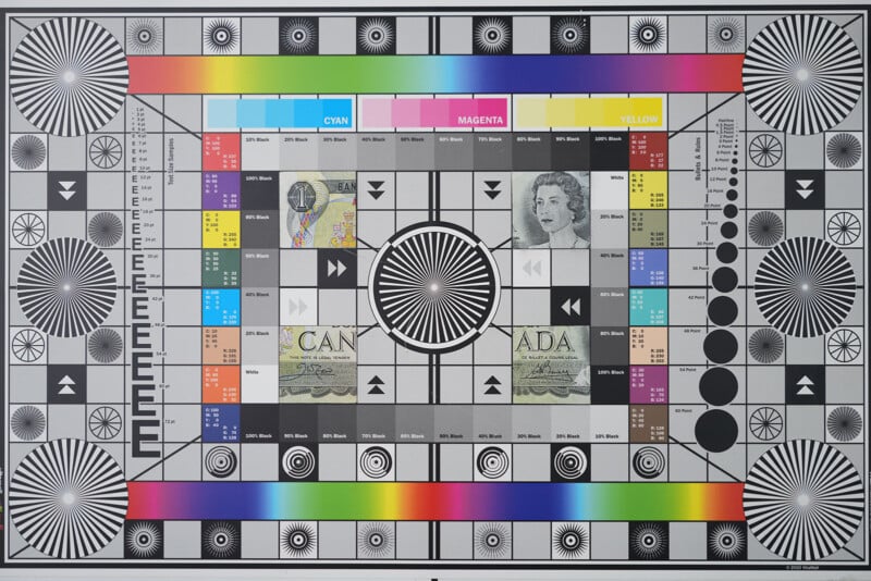 A television test pattern with color bars, grayscale blocks, various geometric shapes, resolution charts, and sections showing Canadian currency and a black-and-white photo of a woman.
