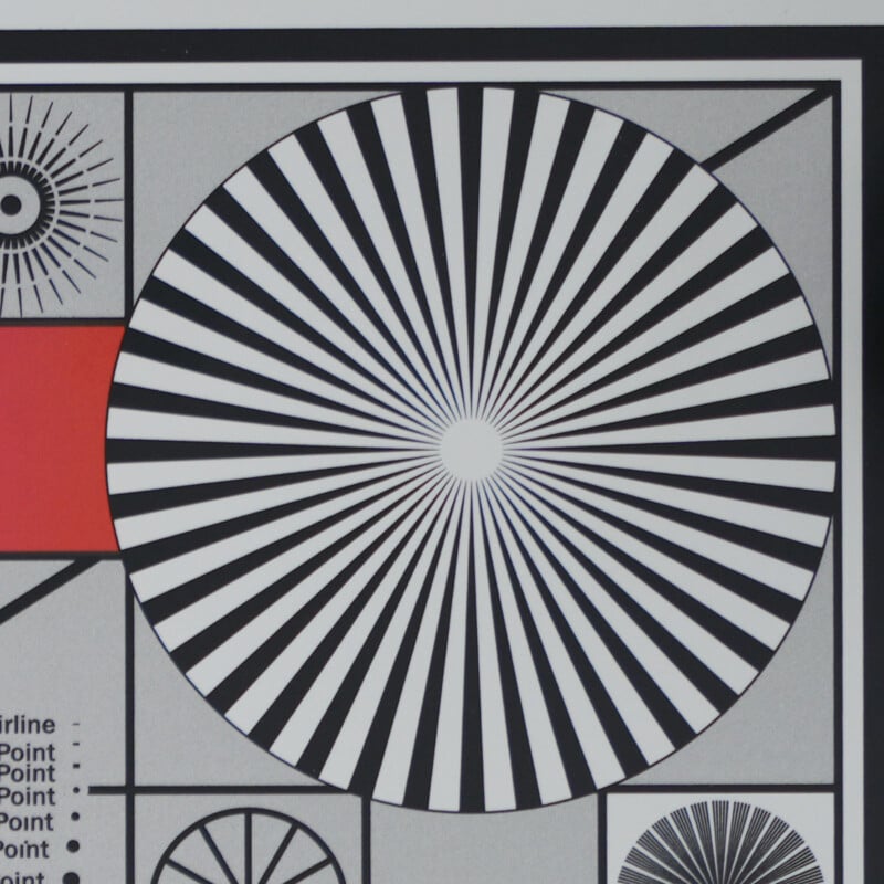 A circular pattern of alternating black and white radial lines resembles a test chart, with a red rectangle to the left and geometric shapes and text in the background.