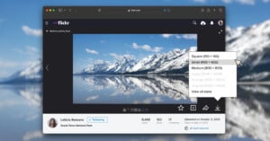 A computer screen displays a Flickr photo of snow-capped mountains reflected in a lake, with a menu open showing image size options like small, medium, and original.