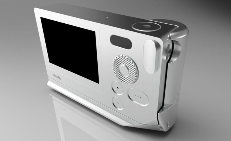 A silver digital camera with a large display screen, multiple round buttons, and a textured circular control pad, shown on a glossy gray surface.