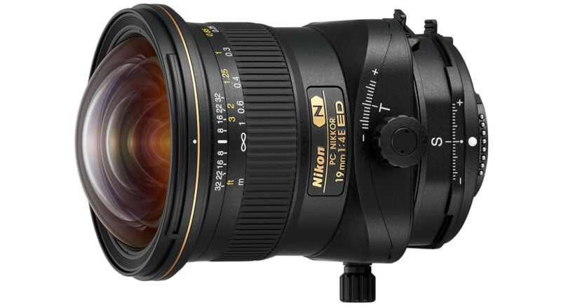 A Nikon NIKKOR 19mm f/4E ED PC tilt-shift lens, shown at an angle on a white background, highlighting its glass element, adjustment knobs, and detailed labeling.