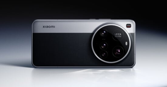 A sleek smartphone with a prominent circular camera module labeled "Leica" on the back. The design features a dual-tone finish with metallic and textured surfaces. The brand name "Xiaomi" is visible on the upper left.