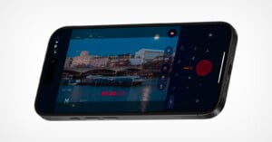 A smartphone displaying a camera app interface, showing a video recording of a cityscape with buildings, a river, and boats, along with camera controls and a recording timer on screen.