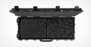 A black hard-shell protective case with an open lid, revealing a grid of cylindrical compartments inside. The lid has egg crate foam padding for cushioning contents.
