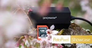 A ProMaster device and a rugged 128GB SD card rest on a mossy branch with blooming cherry blossoms. The image features the Petapixel Showcase logo in the corner.