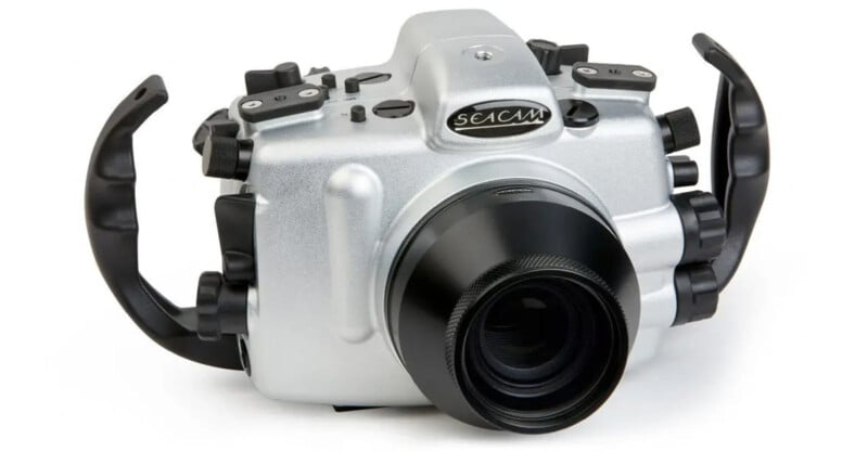 A silver Seacam underwater camera housing with a black lens port, featuring multiple dials and ergonomic grips on both sides, designed for underwater photography.