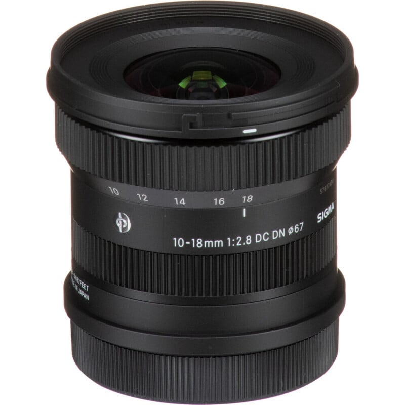 A Sigma 10-18mm f/2.8 DC DN camera lens with a wide-angle design. The lens features focus and zoom rings, distance markings, and a 67mm filter thread. It has a black finish and compact size, ideal for photography enthusiasts.